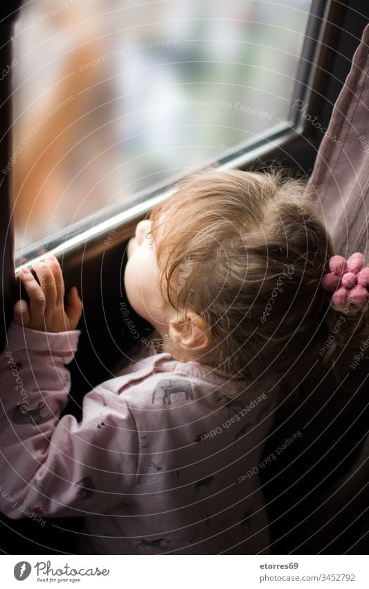 little girl looking out the window baby blonde caucasian concept coronavirus covid.19 flu home house kid outdoor person portrait quarantine stay stay at home
