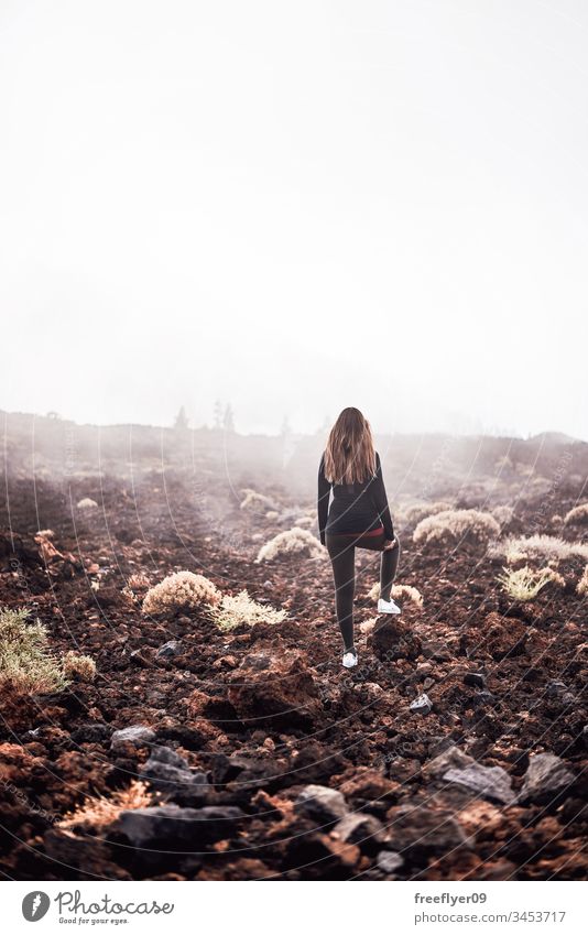Young woman contemplating the fog on her way to Teide top in Tenerife, Spain adult burned caucasian clothes cloudy cold contemplation countryside emotion