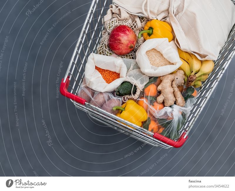 Food waste, zero waste shopping in supermarket eco bag shopping cart food waste trolley fruit vegetables reusable bags grains textile fabric pouch top view flat
