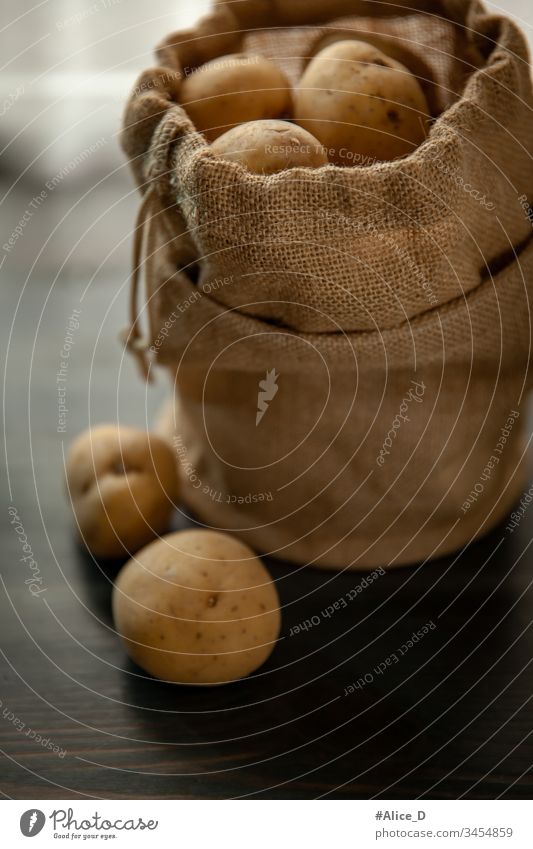Potatoes in burlap on a rustic wooden background Bag Brown sackcloth burlap sack Close-up Culinary Diet Earth Earthy plummeting Food Fresh fresh potatoes Group