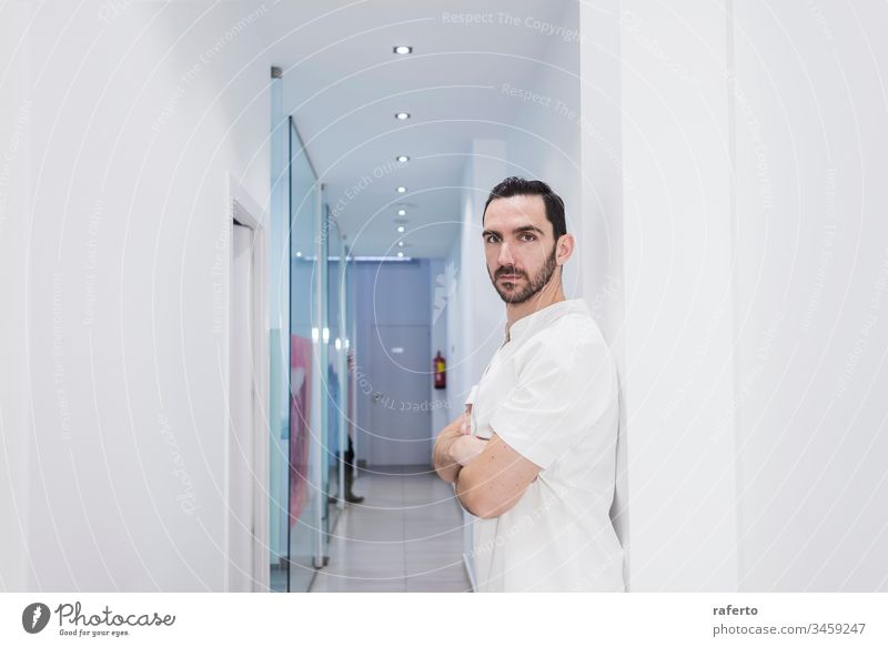 Portrait of a bearded doctor standing in the hospital hallway while looking camera portrait medicine man uniform male professional health surgeon clinic person