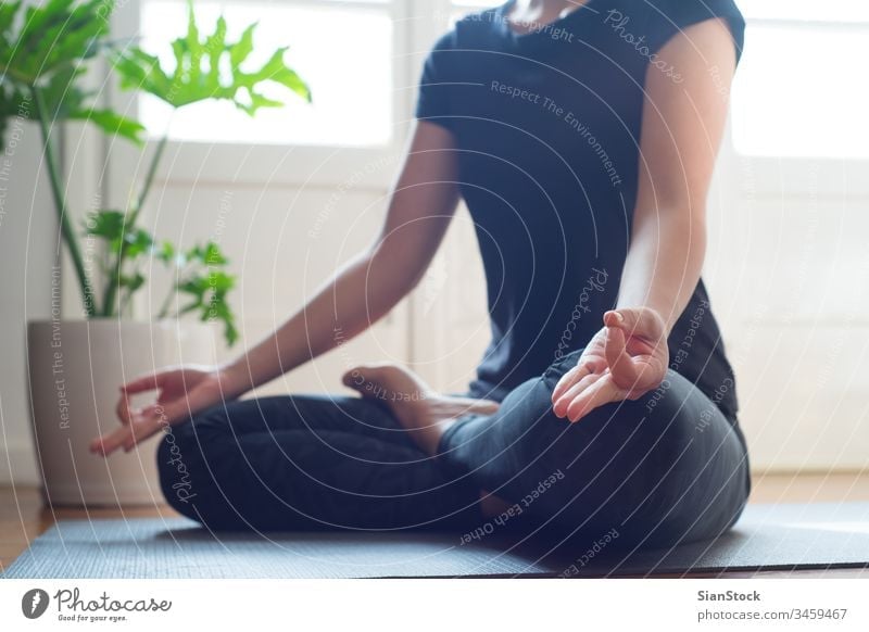Woman doing yoga in the morning at her home. mat woman fitness young lotus pose asana beautiful sport health exercise workout wellness gym female girl pilates