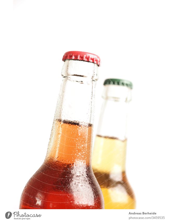 Two ice-cold bottles with organic lemonade against a white background sugar free non-alcoholic isotonic beer glass drink isolated brown beverage liquid green