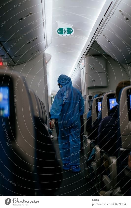 A flight attendant in protective clothing in an aircraft on a return flight for stranded passengers during the Corona Pandemic Airplane Protective clothing