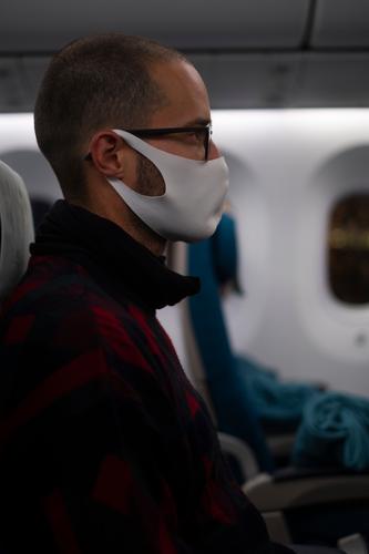 Man sitting in a plane with a face mask during the Corona Pandemic Airplane corona pandemic Face mask Mask fabric mask coronavirus prevention Virus COVID