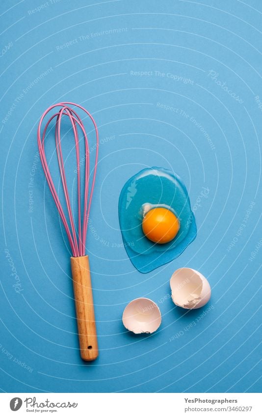 Cracked egg and whisk as a baking concept. blue clean colorful cooking cracked egg egg yolk eggshells flat lay food healthy eating home baking homemade
