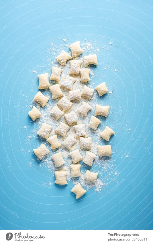 Uncooked gnocchi pile. Cheese gnocchi dumplings on flour Italian above view blue background cheese gnocchi cooking cuisine dinner european flat lay food fresh