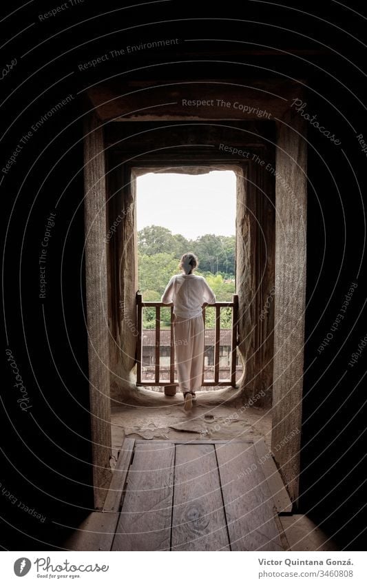 woman looking out the window in a temple Angkor Cambodia Siem Riep architecture asia bright castle door doorway family house indoors light lumber luminous
