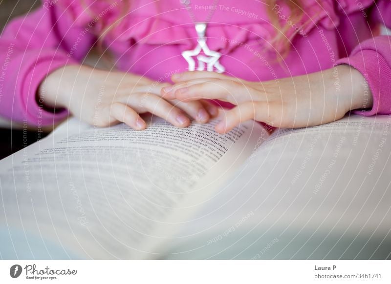 Close up of little girl's hands reading adorable attentive attentively beautiful blonde book bored caucasian child childhood clever closeup concentrated cute