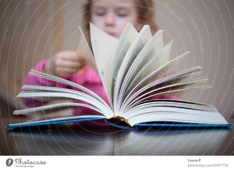 Little blonde girl  reading and doing homework adorable attentive attentively beautiful book bored caucasian child childhood clever closeup concentrated cute