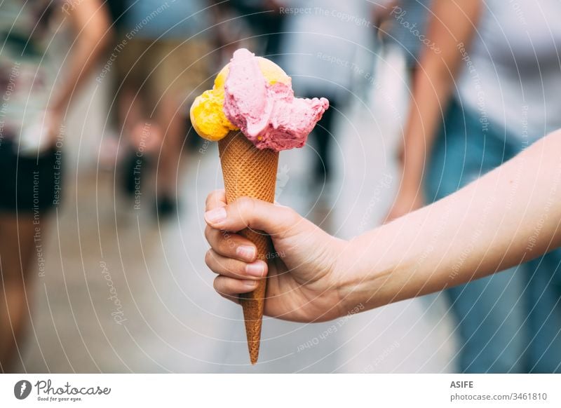 Ice cream is the best snack in summer ice cream cone hand scoop waffle holding street people outdoors woman mango fruit strawberry cold delicious food eating