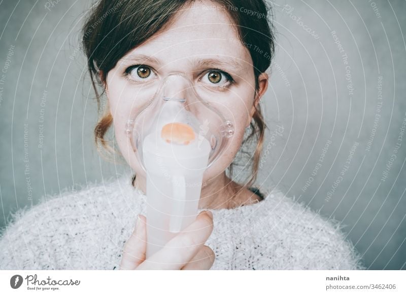 Young woman using a breathing mask covid 19 coronavirus pandemic illness oxygen infected contagious infection allergy asthma health healthy breathing medical