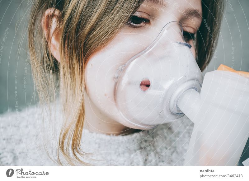 Young woman using a breathing mask covid 19 coronavirus pandemic illness oxygen infected contagious infection allergy asthma health healthy breathing medical