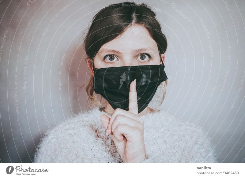 Young woman wearing a face mask and asking for silence covid 19 coronavirus breath pandemic secret lies calm patience illness infected contagious infection