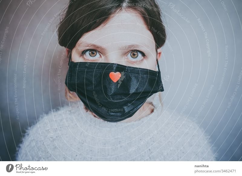 Young woman wearing a mask with a red heart on it covid 19 coronavirus breath pandemic illness hope love help solidarity empathy care infected contagious