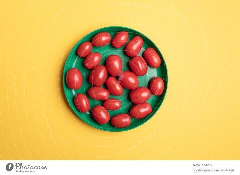Date tomatoes in a green plastic plate tomato with dates Plate Green Yellow Middle Vegetable Nutrition Red Deserted Healthy Eating Food photograph Tomato