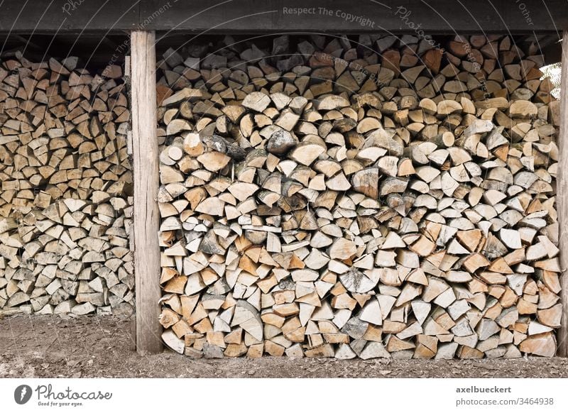 stacked firewood in wood shed fire wood woodpile chopped natural lumber timber material background tree cut energy forest log industry wooden outdoors fuel
