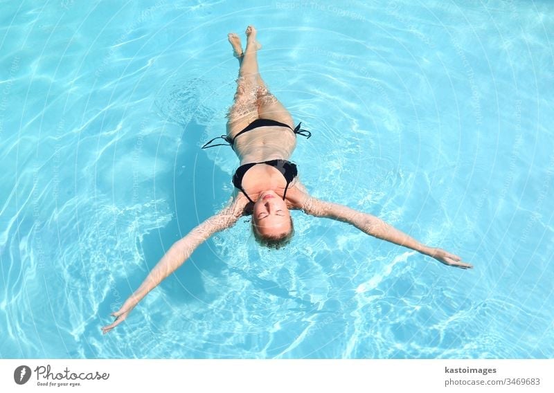 Caucasian lady floating in swimming pool. woman water blue travel vacation beauty summer adult attractive beautiful bikini body calm caucasian female fun girl
