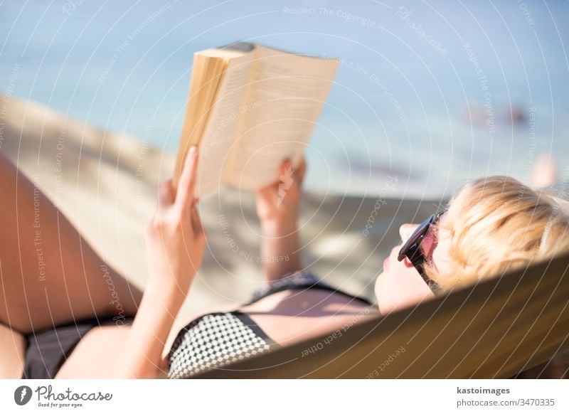 Lady reading book in a hammock. adorable attractive beach beautiful beauty bikini blonde blue body caucasian closeup education face female girl happy healthy