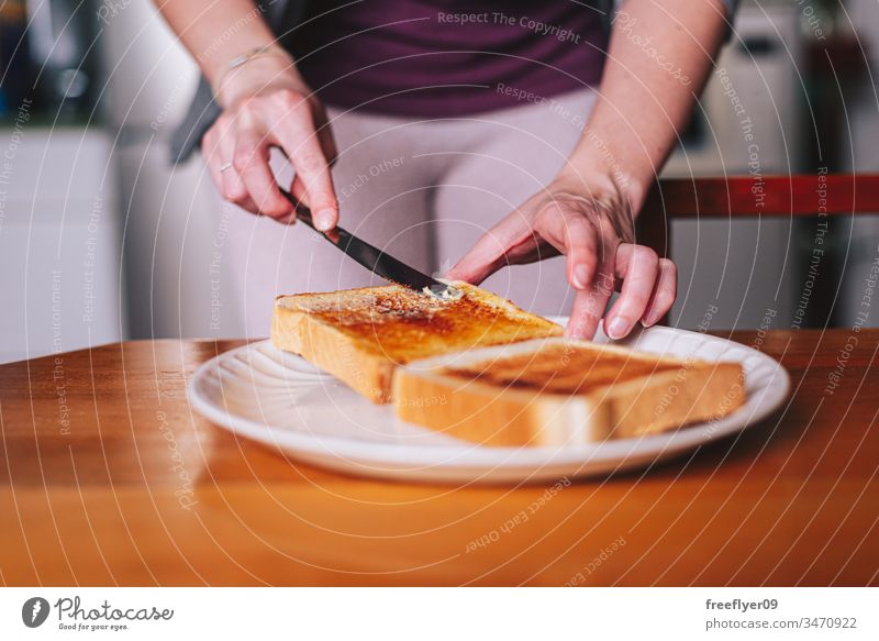 two hands spreading butter on toast plate breakfast knife food kitchen morning meal margarine widener organic snack bread human whole freshness piece