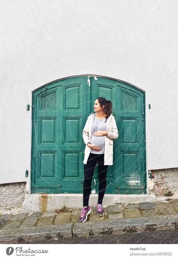 Young pregnant woman in front of a green door Pregnant youthful Woman Green Door Baby bump