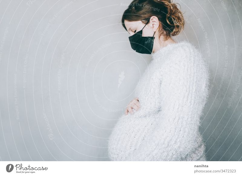 Young pregnant woman wearing a mask during covid 19 pandemic coronarivus pregnancy influenza mom mother risk group of risk fear motherhood parenthood family