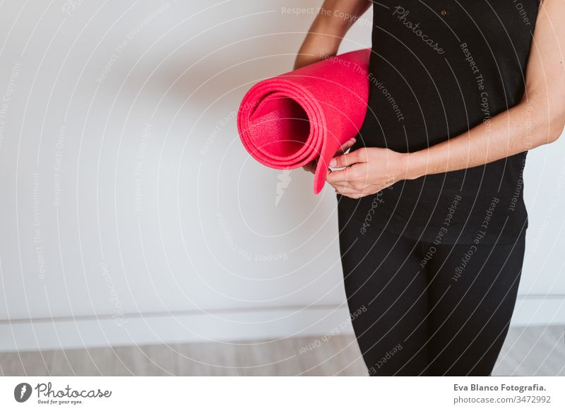 unrecognizable Young woman listening holding yoga mat, ready to practice. Healthy lifestyle indoors home one young caucasian sport healthy stay home stay safe