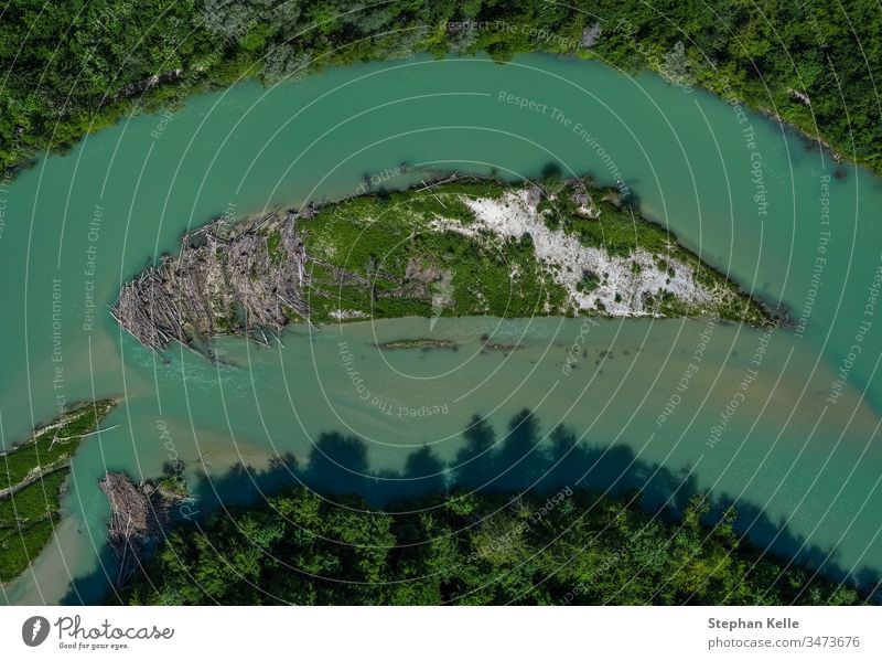 A lonely island in the Isar river in vertical view from a drone topdown isar munich water tree special idyllic bavaria curve from above high angle view amazing
