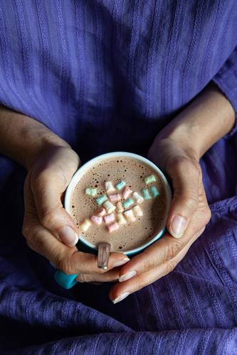 A woman in a purple dress holds with both hands a turquoise cup with cappuccino decorated with mini-marshmallows Cup Cappuccino hold cup Coffee Beverage