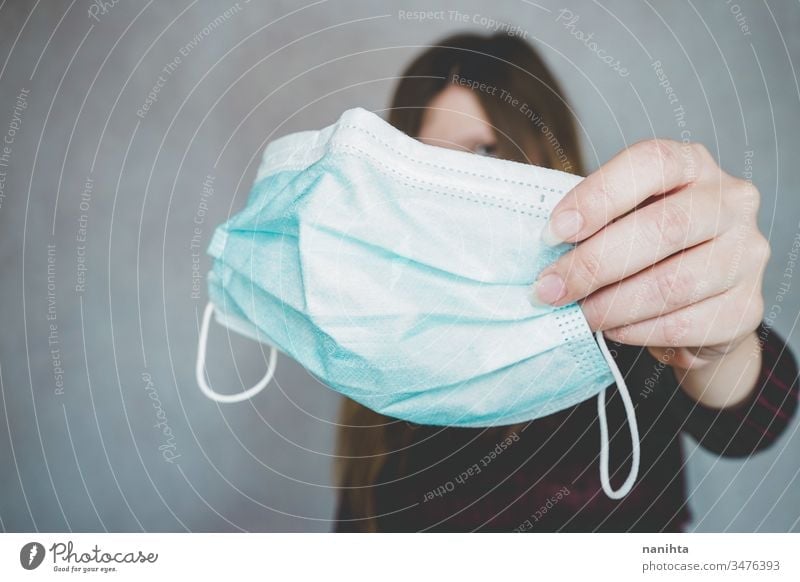 Someone holding a traditional med face mask covid 19 flu influenza coronavirus pandemic epidemic illness respiratory illness social distance contagion risk