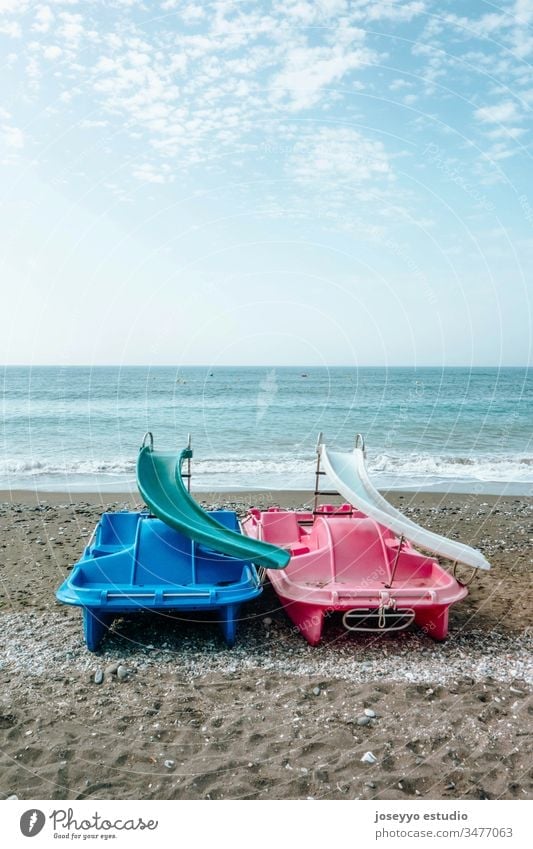 Pedal boats on the sand in the seashore. activity attraction beach blue boating catamaran clouds coast cycle day entertainment fun holiday holidays horizon