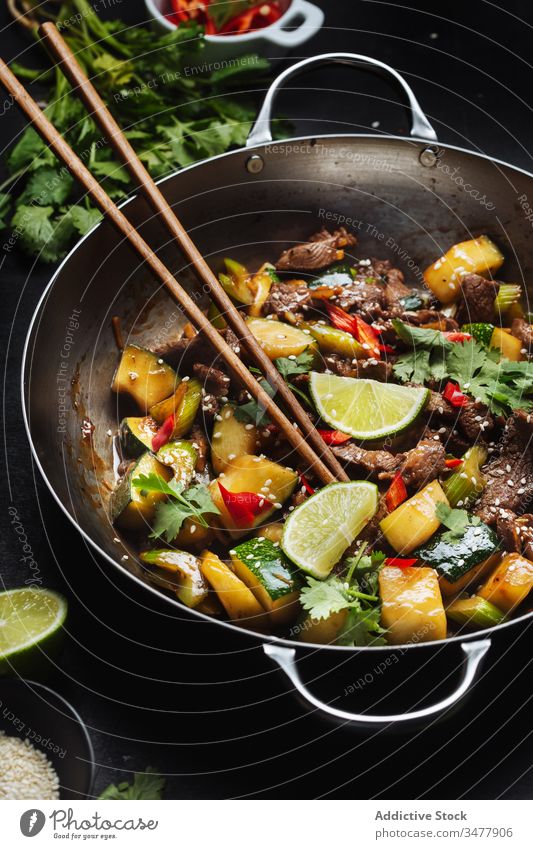 Oriental cuisine dish with meat and vegetables stir fried wok zucchini oriental food spice lime asian tradition chopstick meal delicious tasty dinner cook lunch