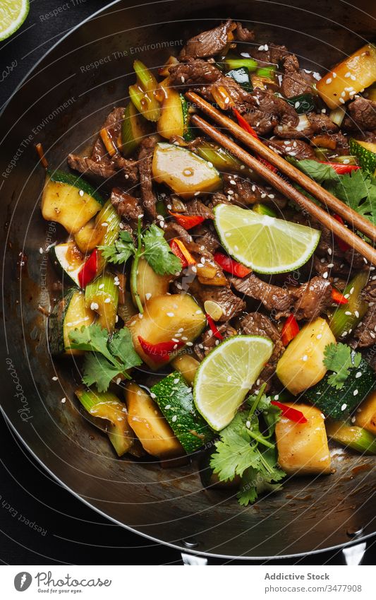 Oriental cuisine dish with meat and vegetables stir fried wok zucchini oriental food spice lime asian tradition chopstick meal delicious tasty dinner cook lunch