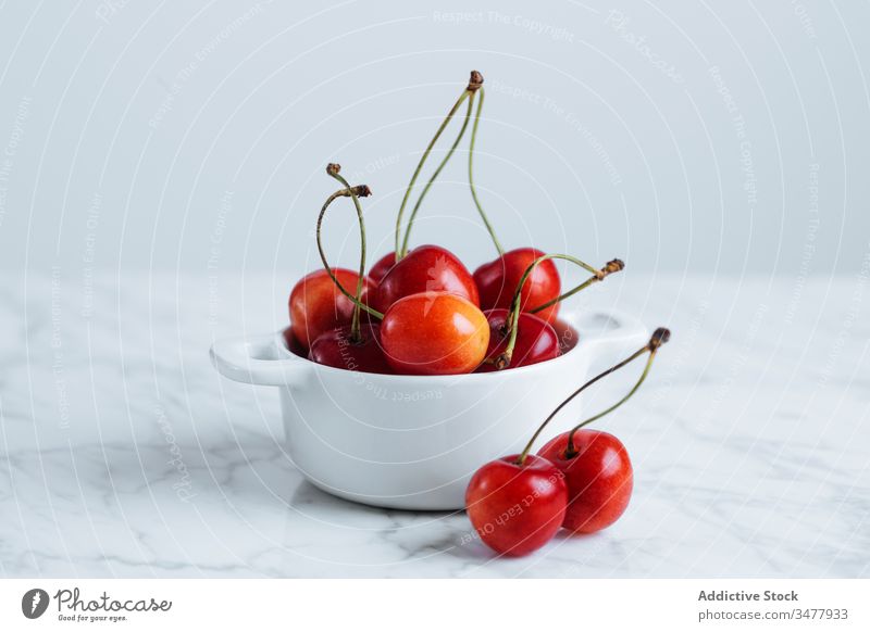 Red cherry in white bowl on table red berry fruit fresh ripe natural food healthy pot pile plant stalk vitamin sweet tasty delicious raw season summer colorful