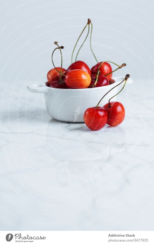 Red cherry in white bowl on table red berry fruit fresh ripe natural food healthy pot pile plant stalk vitamin sweet tasty delicious raw season summer colorful