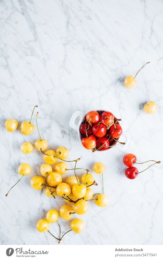 Fresh cherry on marble table red yellow berry fruit fresh ripe natural food healthy bowl glass pot pile plant stalk vitamin sweet tasty delicious raw season