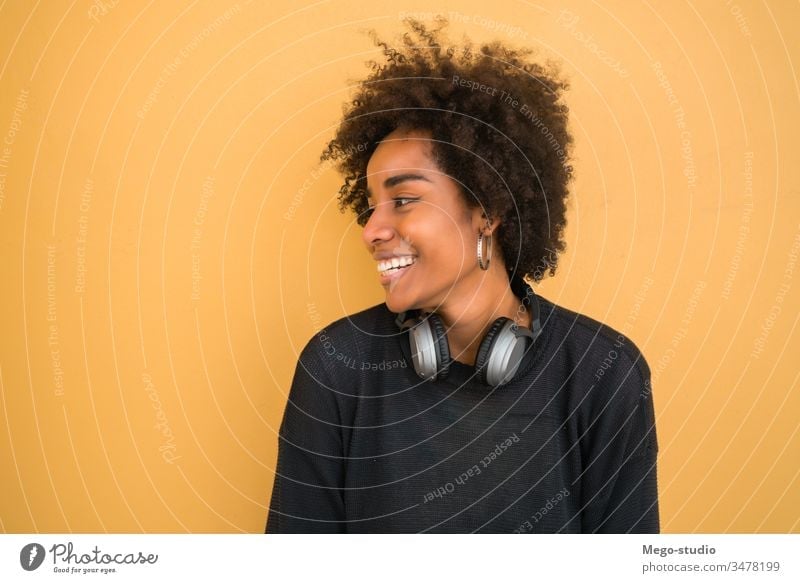 Portrait of young afro american woman. beautiful yellow background adult hairstyle lovely wall standing image look gesture cheerful lifestyle ethnicity mixed