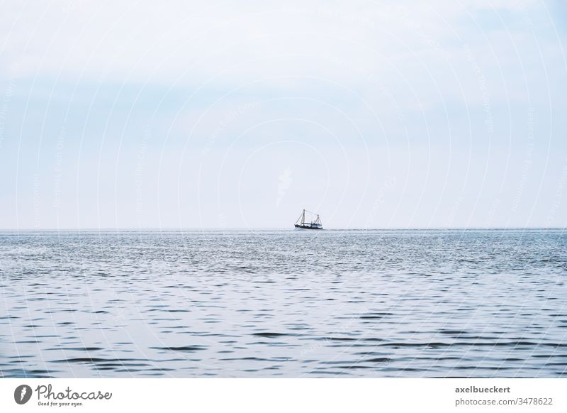 distant shrimp boat on the north sea ocean fishing ship water germany fishery fisheries commercial calm tranquility nature blue industry trawler marine