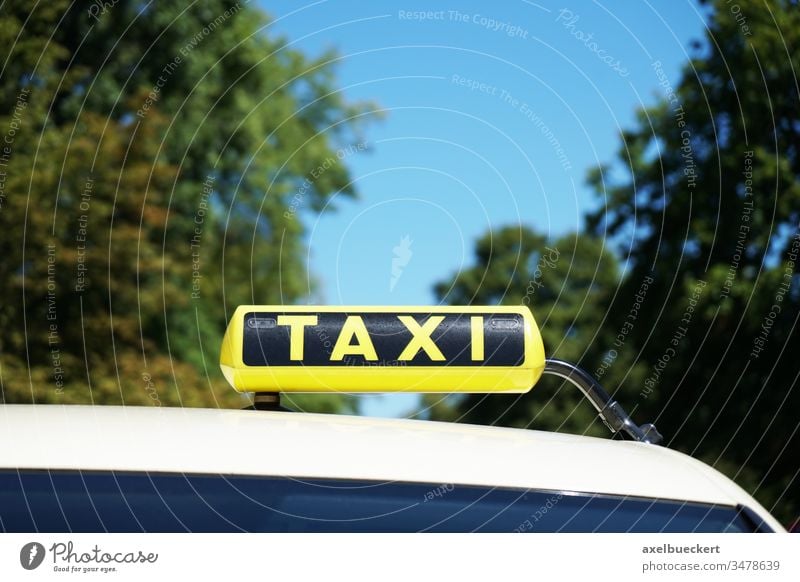 german taxi sign on car roof cab yellow taxi stand taxicab closeup close-up traffic transport transportation travel nature tree sky copy space copyspace symbol