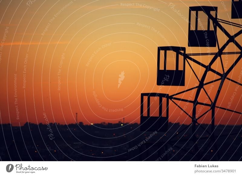 Old Ferris wheel at sunset over a city Shadow Silhouette Sunset Orange Yellow Sky Exterior shot Deserted Evening