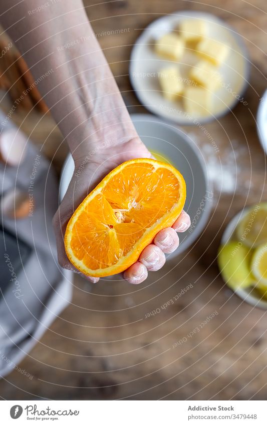 Woman showing half orange over bowl hands prepare recipe ingredient kitchen food cook homemade fresh juice cuisine culinary gastronomy sweet squeeze pastry
