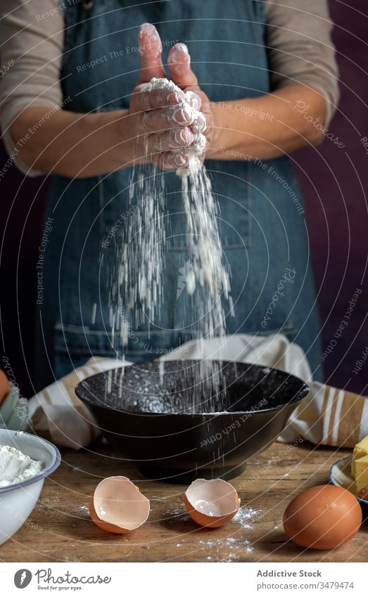 Woman clapping hands with flour into a bowl on table woman egg wooden table pastry cake bakery gourmet cooking ingredient female culinary homemade rustic