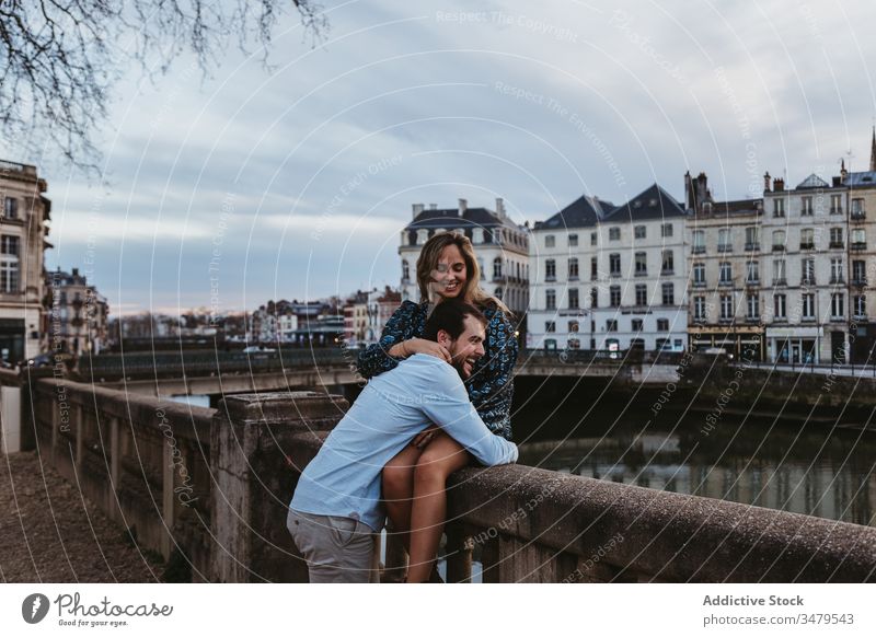 Happy couple enjoying time together in romantic city love relationship embrace happy fence stone travel boyfriend france bayonne girlfriend hug date affection
