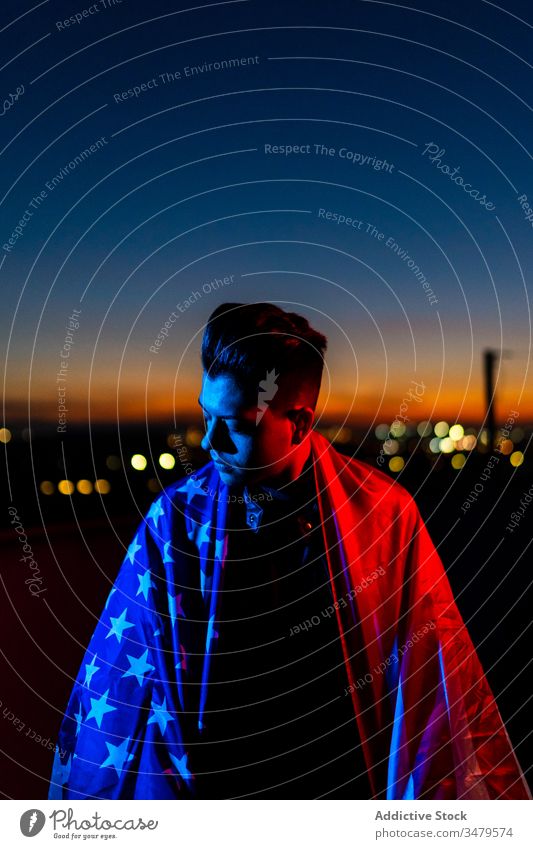 Man with American flag against night sky man american red blue patriot sunset confident freedom dark street evening nation male twilight young dusk casual
