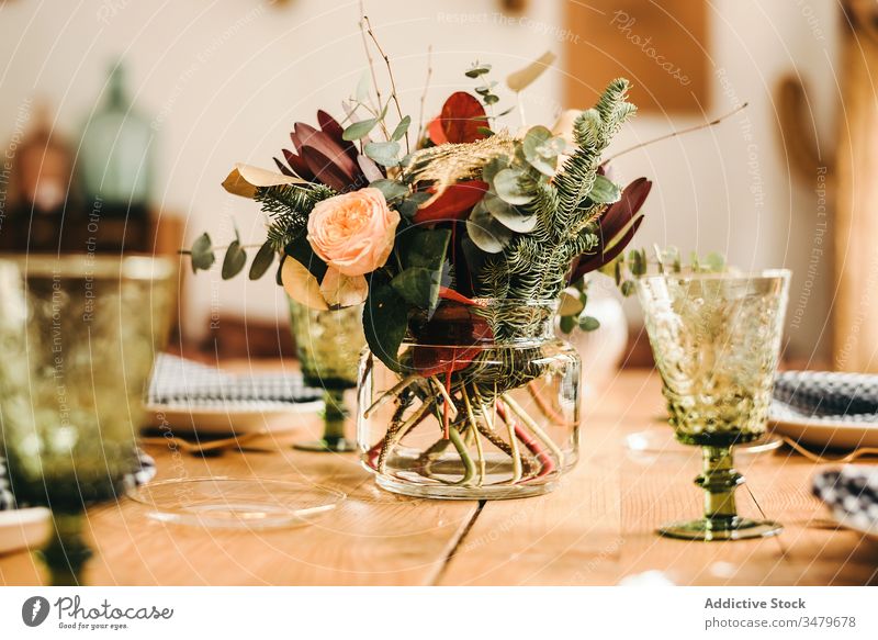 Flowers and plant twigs on a vase decorating a wooden table flowers bunch leaf bouquet water petal concept glass fresh bloom interior vintage nature decorative