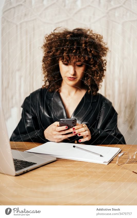 Vintage female entrepreneur with smartphone making notes businesswoman notebook office using retro jacket work laptop device leather gadget workplace job