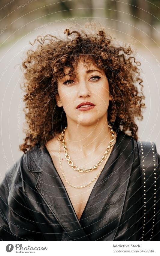 Delighted retro businesswoman on street city smile leather jacket adult curly hair commute work outfit style happy female delight optimist model fashion trendy