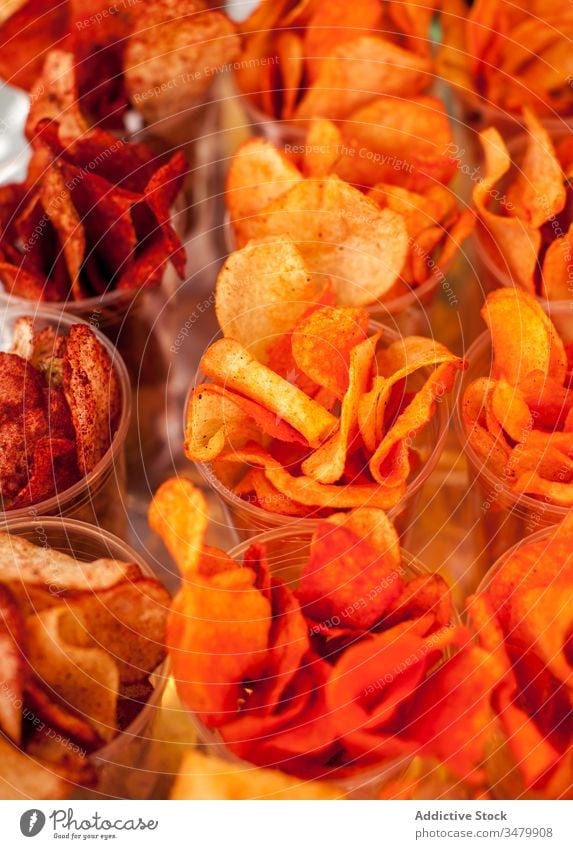 Assorted chips in plastic cups for sale snack crispy assorted food savory spicy background orange crunch yummy delicious tasty meal junk appetizer lunch