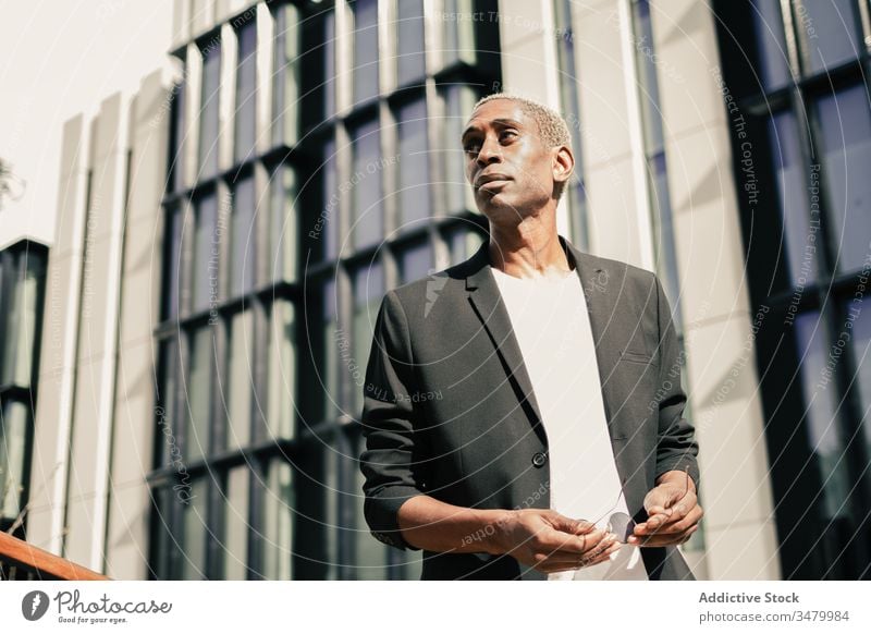 Stylish black businessman on street style city building success ethnic urban modern confident male professional entrepreneur contemporary executive smart