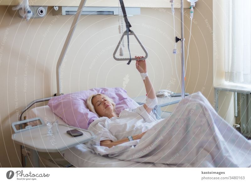 Bedridden female patient recovering after surgery in hospital care. bed sick woman healthcare medical medicine ill room recovery illness ward bedridden